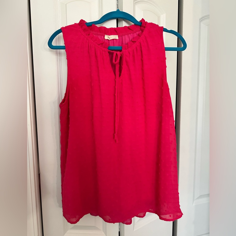 Pink sleeveless blouse with tie neck. Textured fabric.